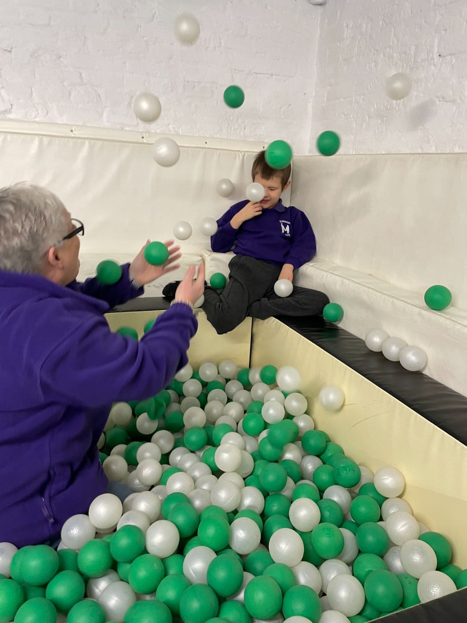 young person in ball pool interacting with staff